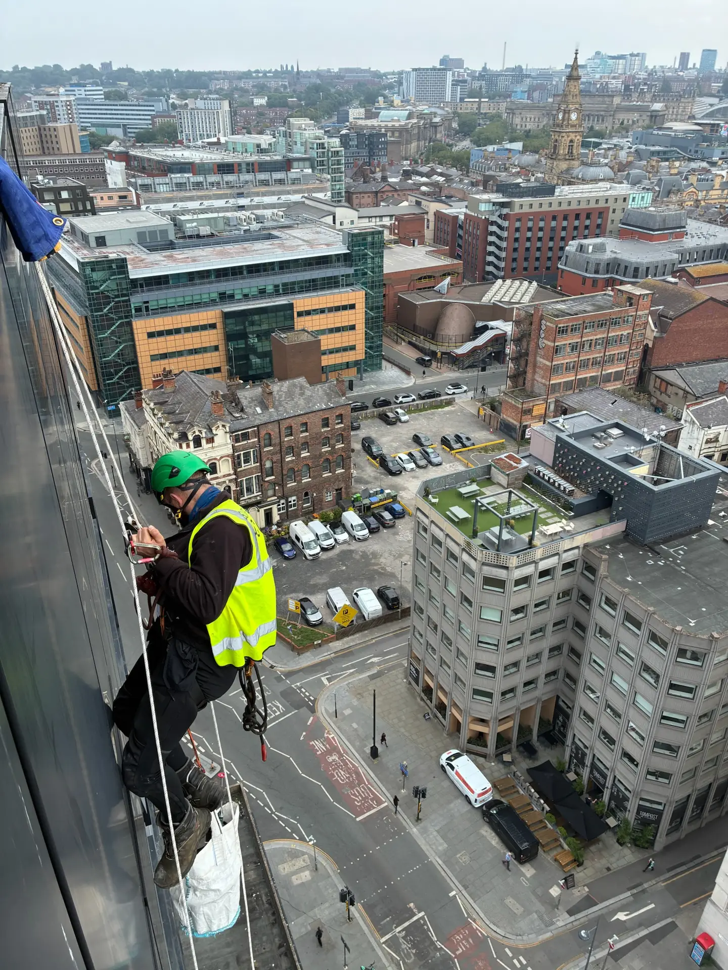 Rope access technician cleaning building facade